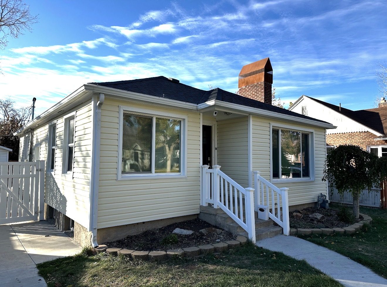 Cottage home after, new Classic Cream vinyl siding with white-wrapped window sills