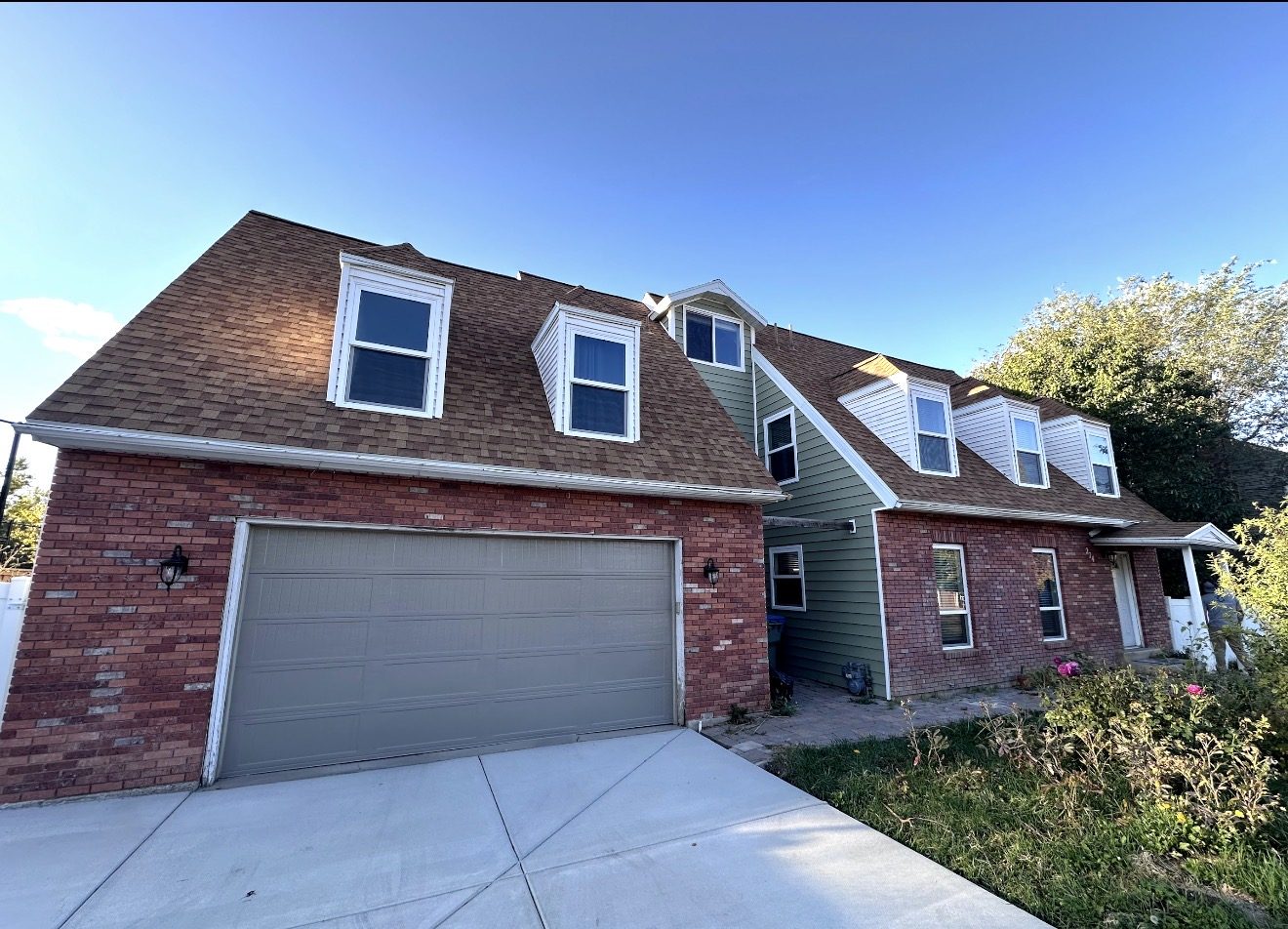 Home before, dated green vinyl siding above brick