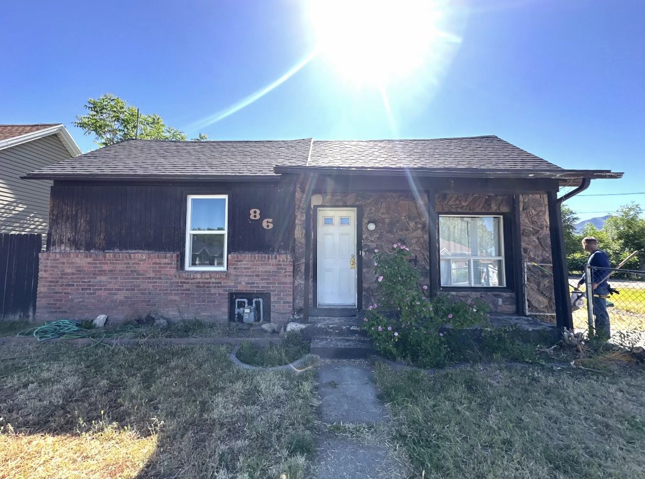 Home before, dark wood paneling and rock accents on a dated ranch home