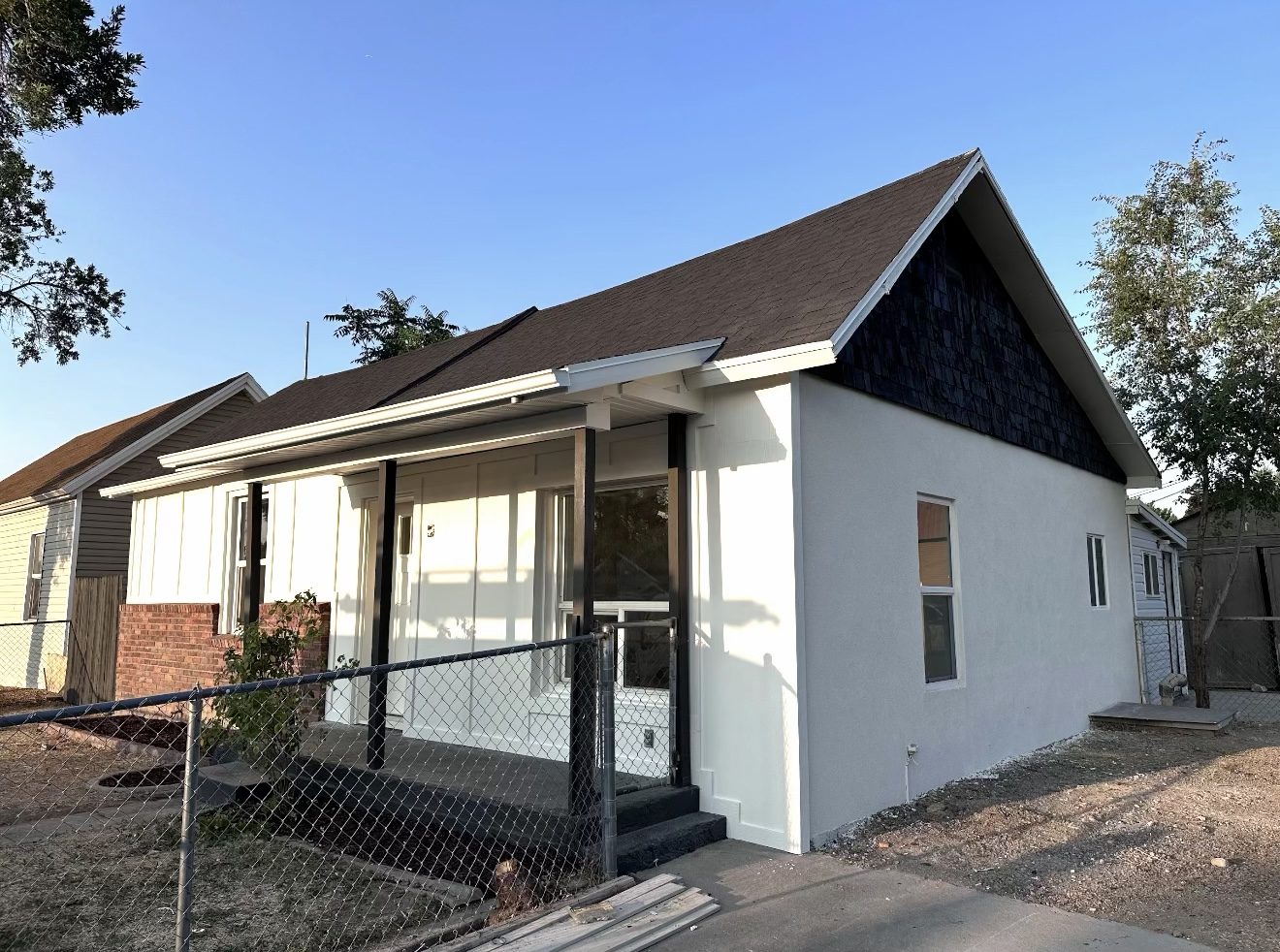 Side of home after, new stucco over cinderblock and painted wood shake in the gable