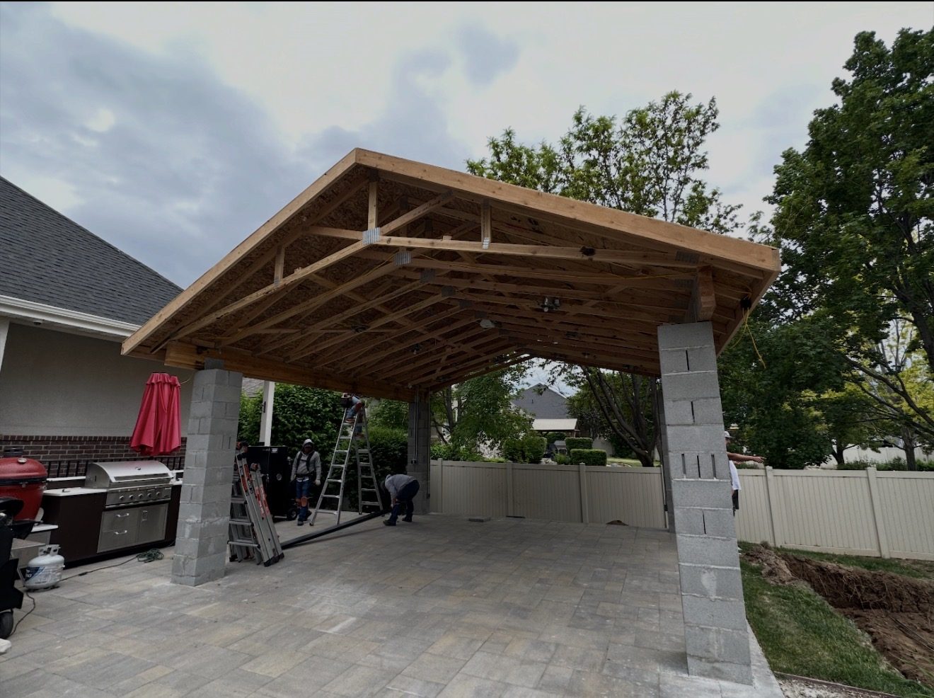 Pavilion before, bare cinderblock columns and unfinished wood truss roof