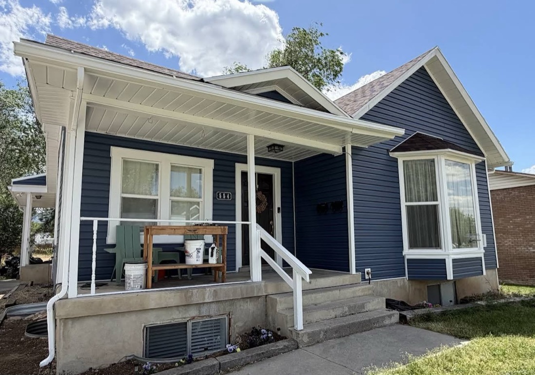 Home exterior after remodel, new navy siding with white trim