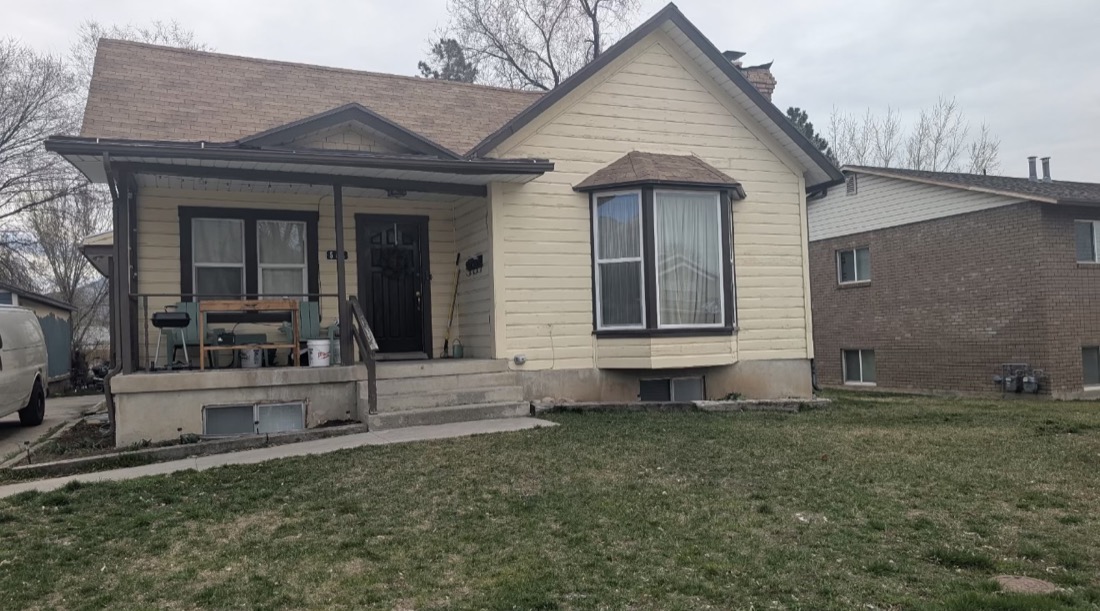 Home exterior before remodel, faded yellow siding