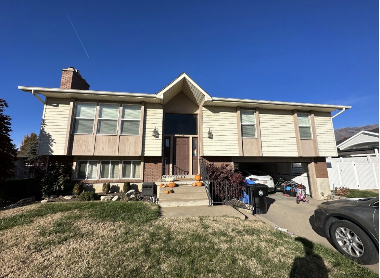 Split-level home before, dated tan 1970s wood paneling siding